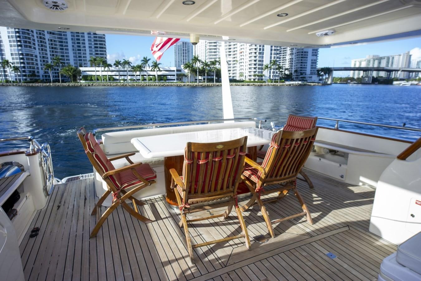 a deck with chairs and tables on it by a body of water aboard KARTESSA III Yacht for Sale