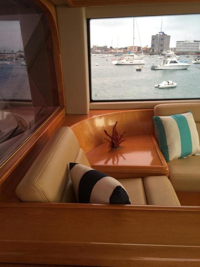 a couch and a table in a room with a window aboard IN FLIGHT Yacht for Sale