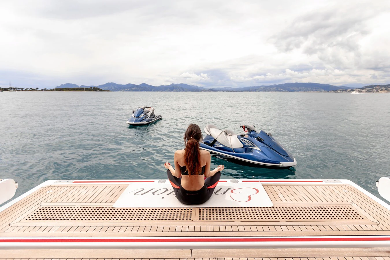 a person sitting on a dock next to a boat aboard EMOTION 2 Yacht for Charter