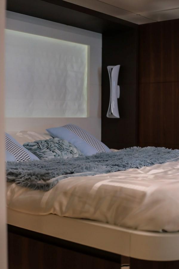 a bed with a blue blanket aboard SEDA Yacht for Sale