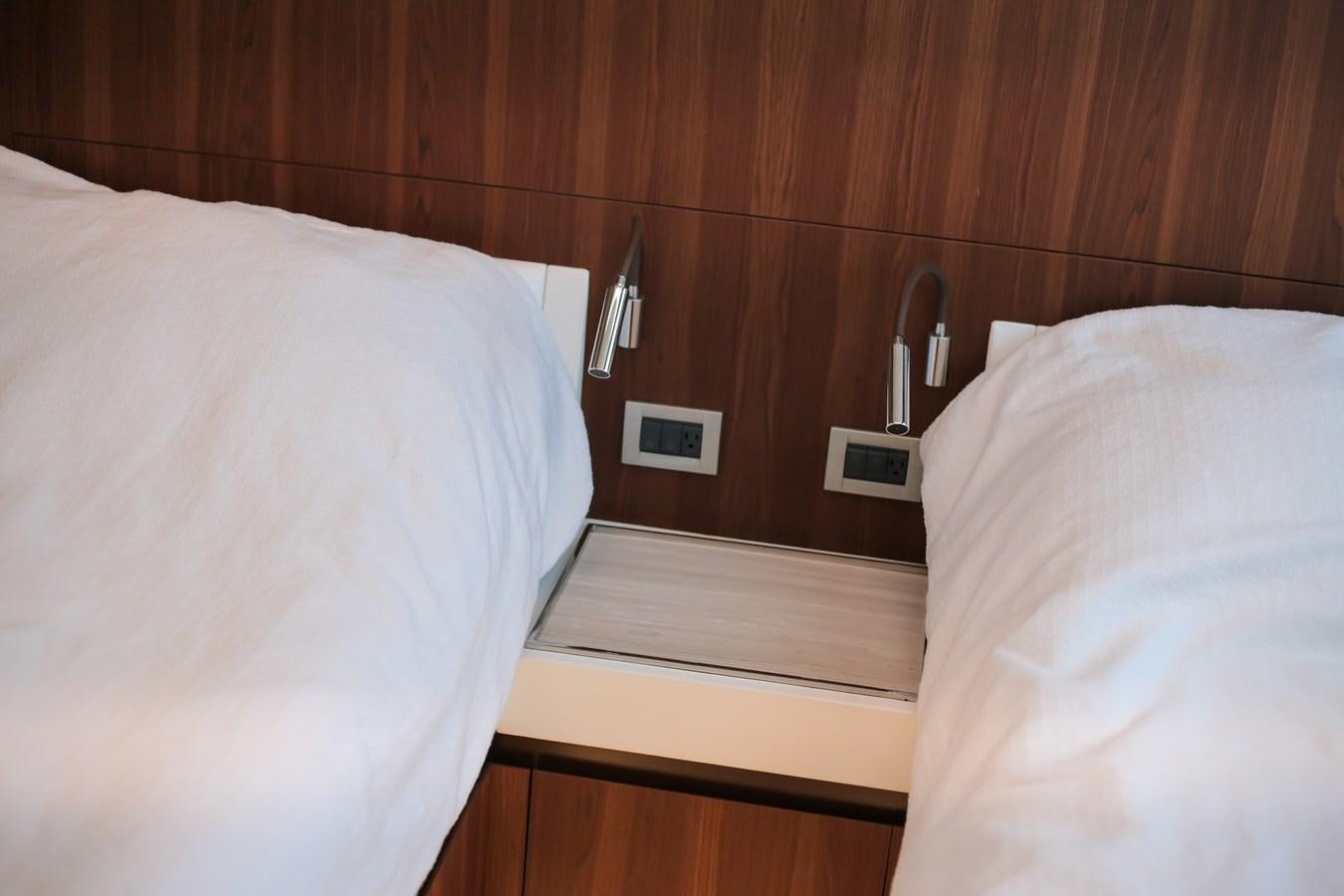 a bed with a phone on the side aboard SEDA Yacht for Sale