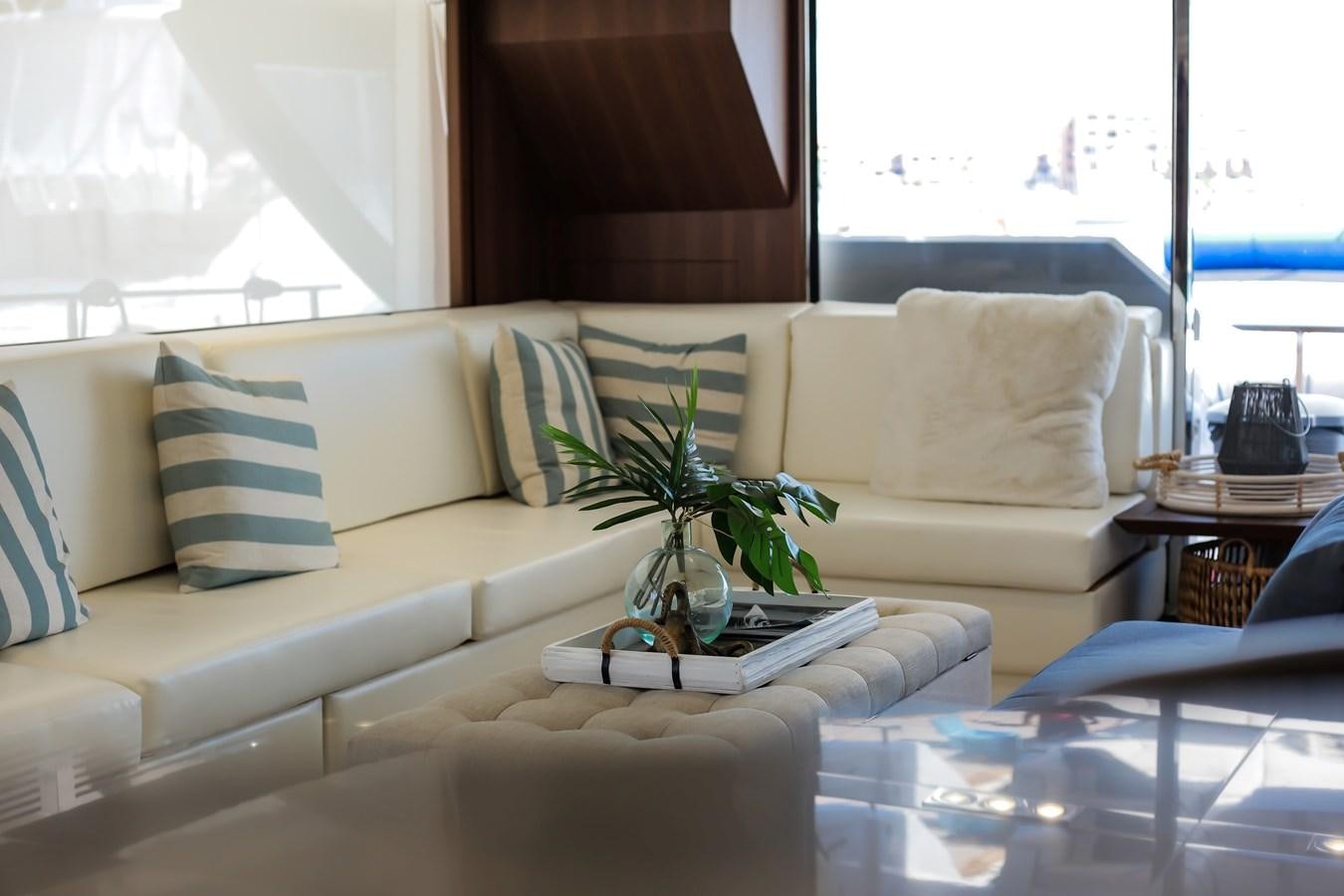 a living room with a white couch and a plant on a table aboard SEDA Yacht for Sale