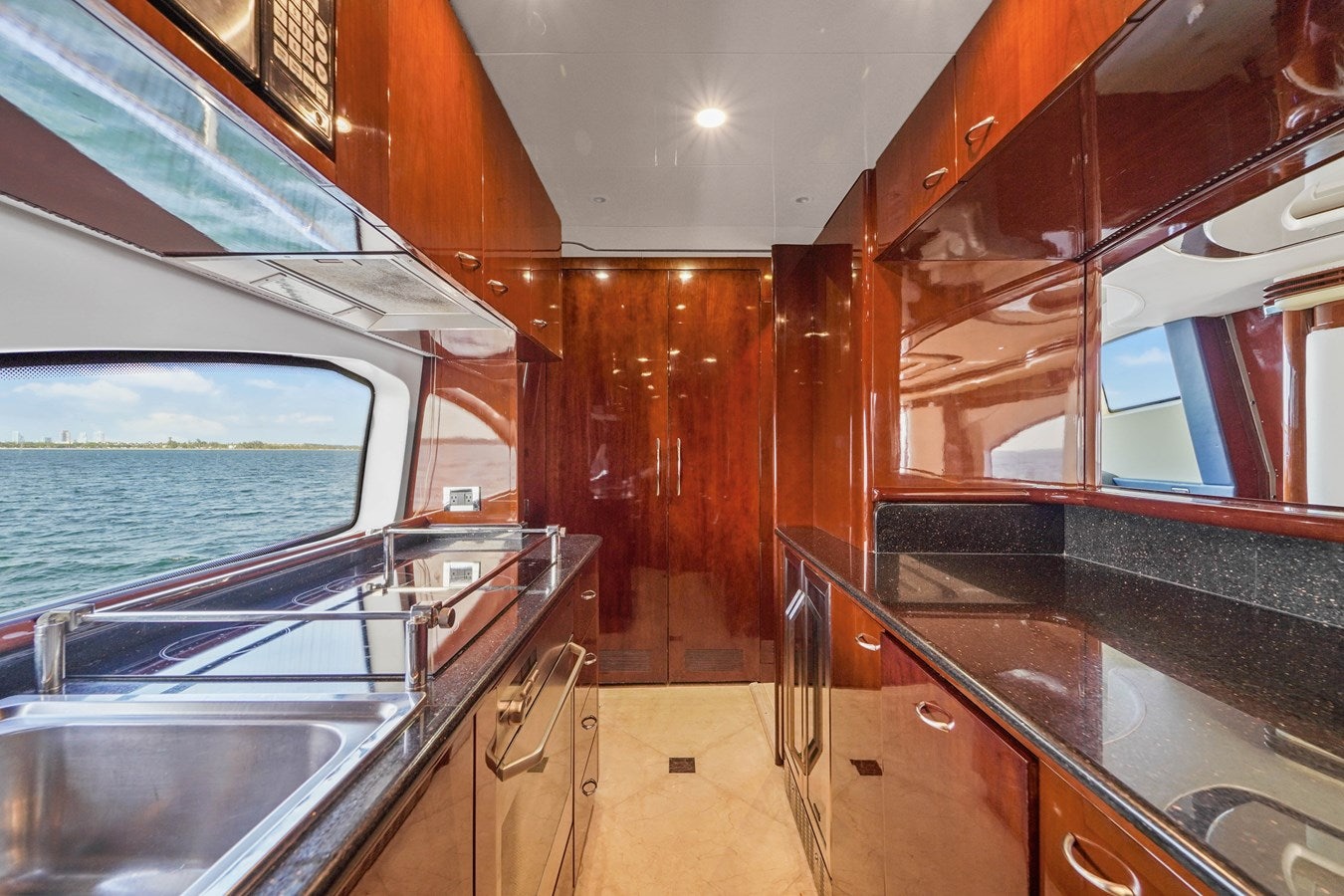 a kitchen with wooden cabinets aboard AZIMUT 80 2003 Yacht for Sale