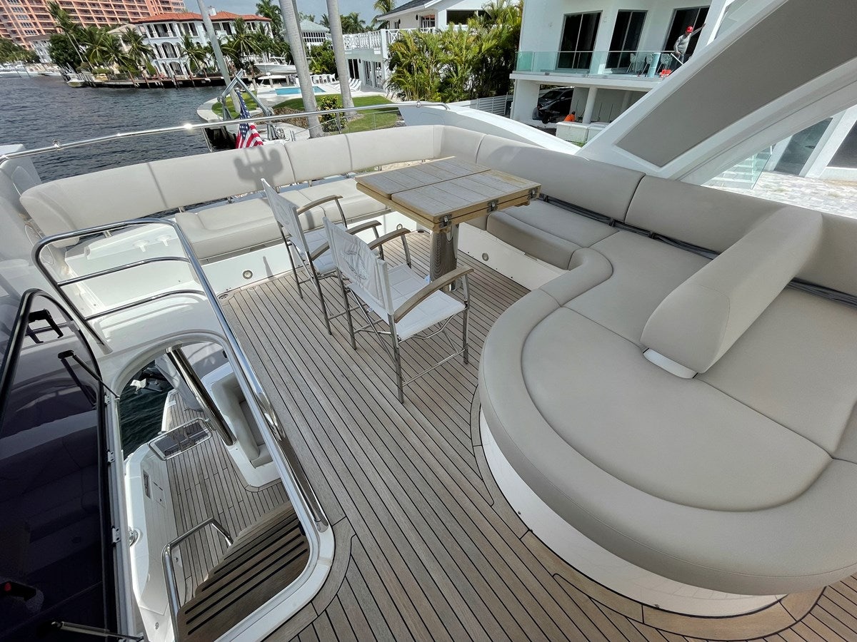 a deck with a table and chairs on it aboard 66 MANHATTAN Yacht for Sale