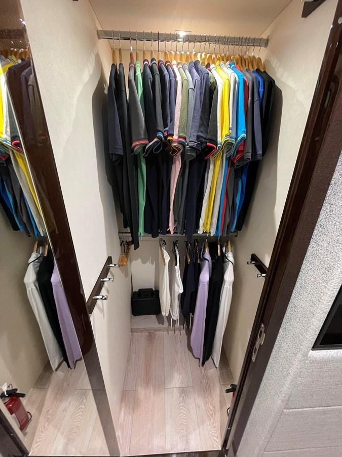 a closet with clothes on the wall aboard 66 MANHATTAN Yacht for Sale