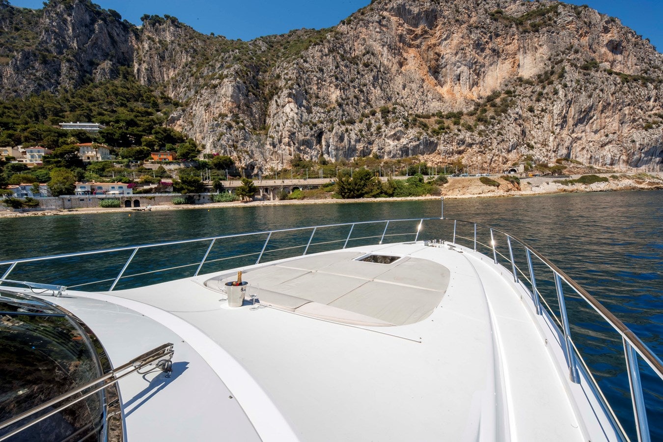 a large white boat on a body of water with hills in the background aboard ULTIMA BEACH Yacht for Sale