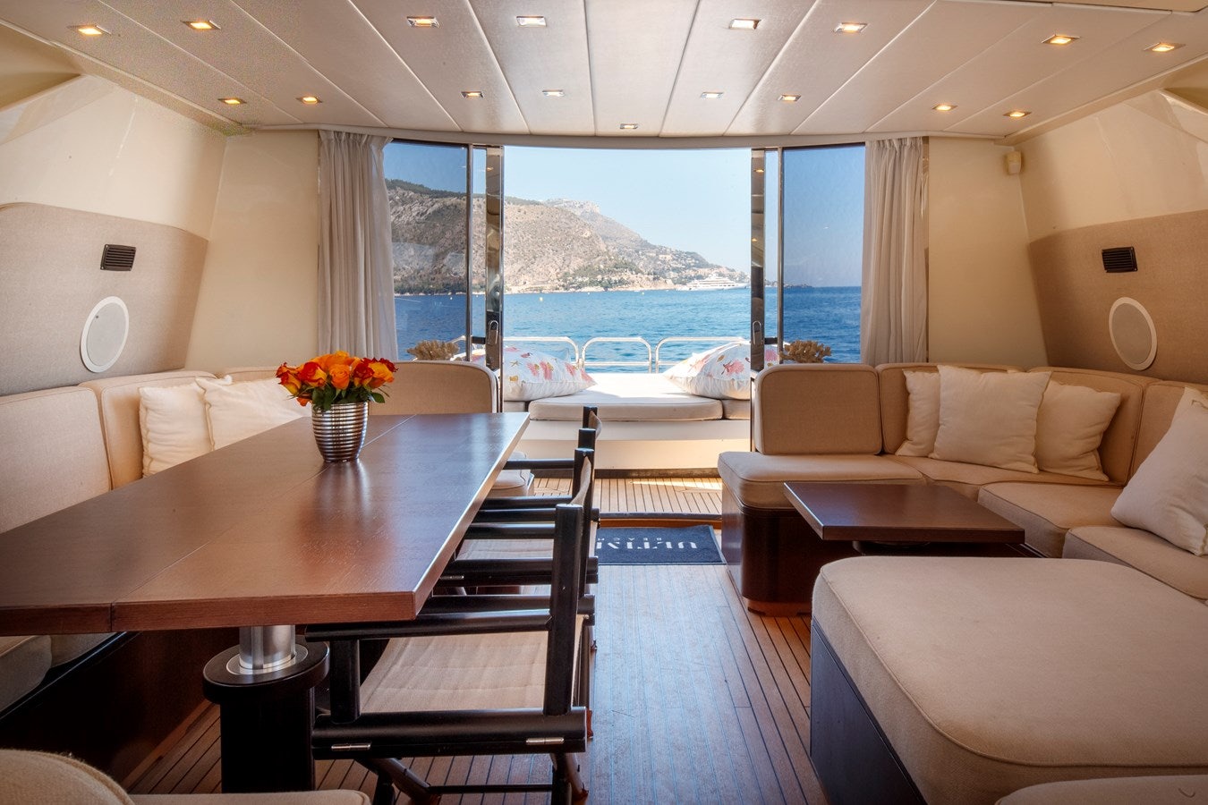 a living room with a table and couches aboard ULTIMA BEACH Yacht for Sale