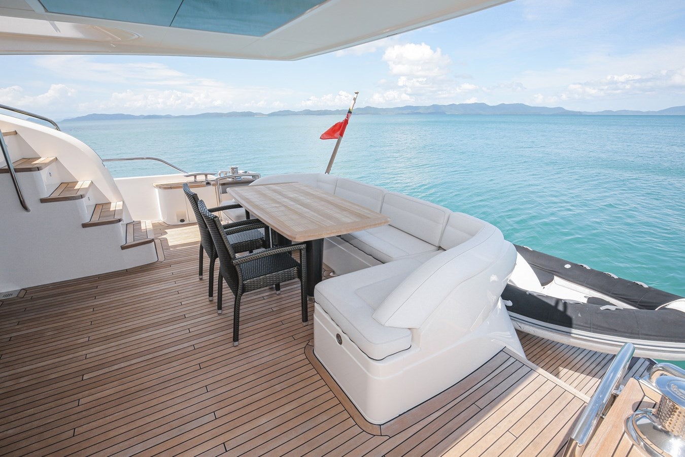 a deck with chairs and tables on it by the ocean aboard SE1 Yacht for Sale