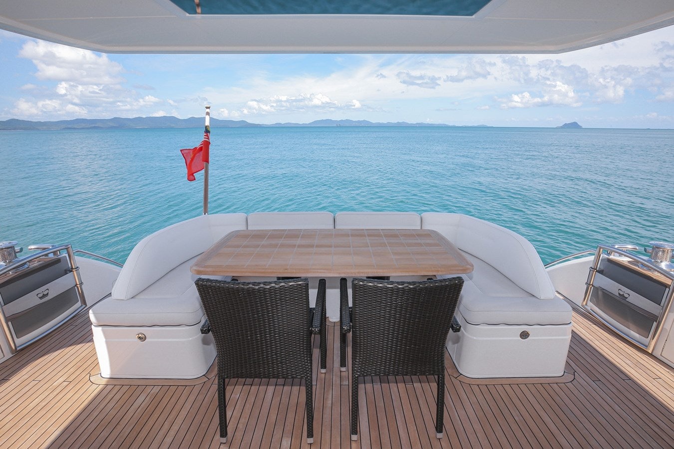 a table and chairs on a deck overlooking a large body of water aboard SE1 Yacht for Sale