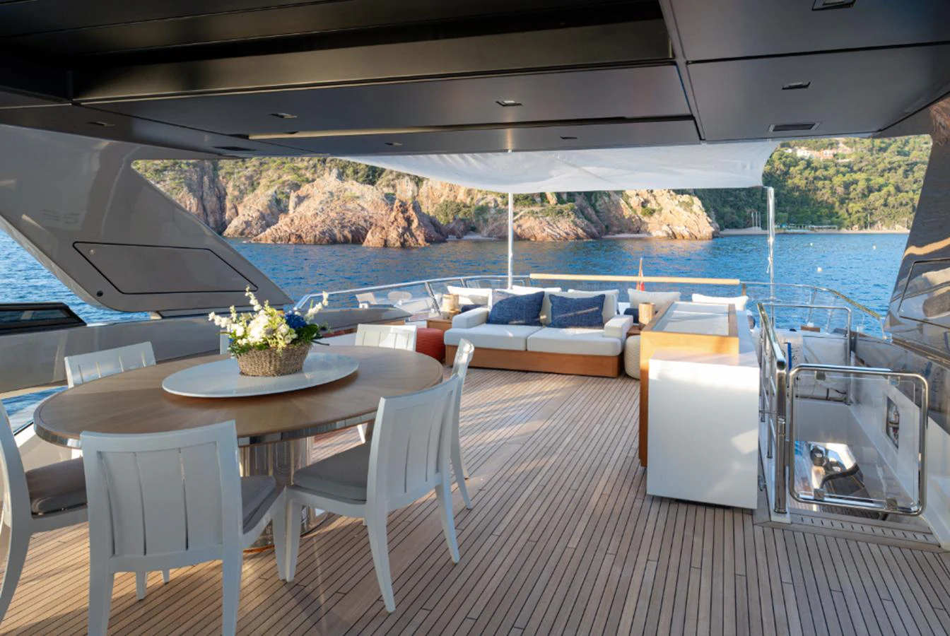 a table and chairs on a deck overlooking a body of water aboard THE GREAT ESCAPE Yacht for Sale