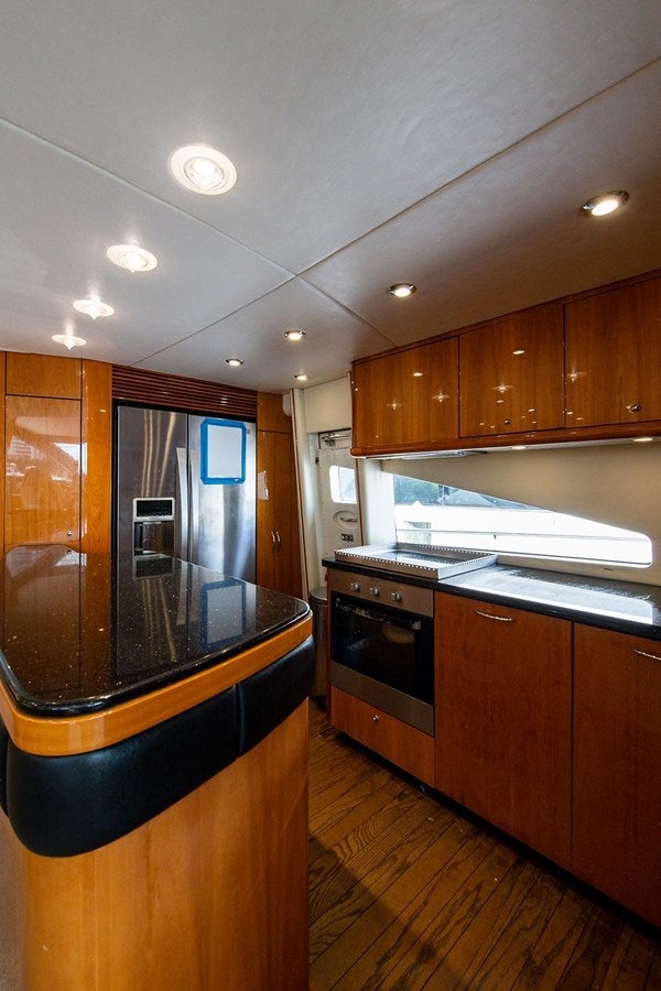 a kitchen with wooden cabinets aboard 82 SUNSEEKER MANHATTAN  Yacht for Sale