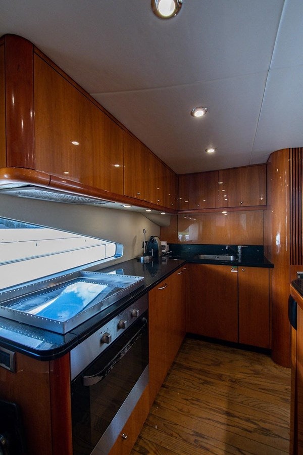a kitchen with wooden cabinets aboard 82 SUNSEEKER MANHATTAN  Yacht for Sale