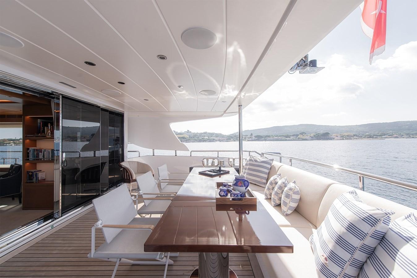 a room with a table chairs and a view of the ocean aboard ASLAN Yacht for Sale