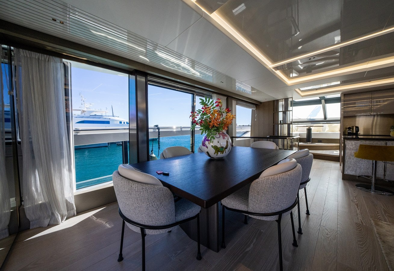 a large room with a table and chairs and a large window aboard BANDAZUL Yacht for Sale