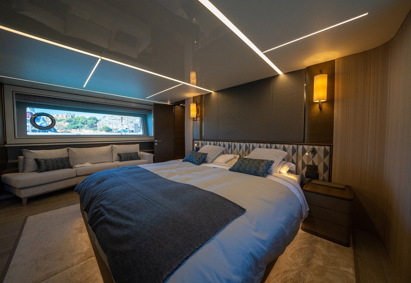 a bedroom with a bed and a couch aboard BANDAZUL Yacht for Sale
