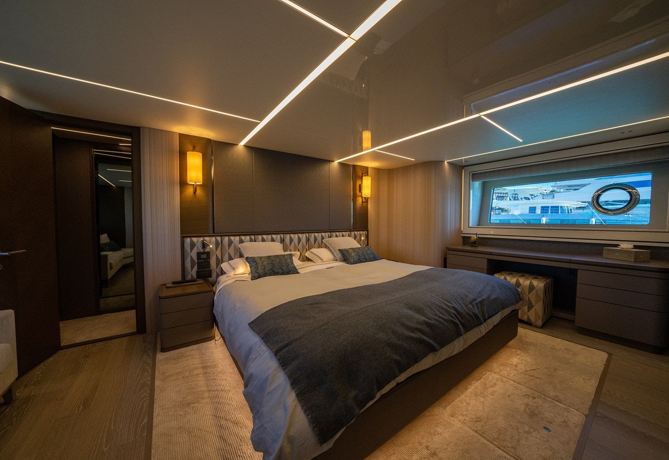 a bedroom with a bed and a tv on the wall aboard BANDAZUL Yacht for Sale