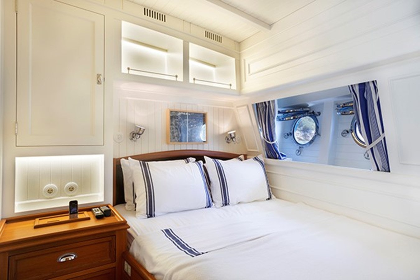 a white bed with a white bed spread and a white wall aboard DARWIN Yacht for Sale