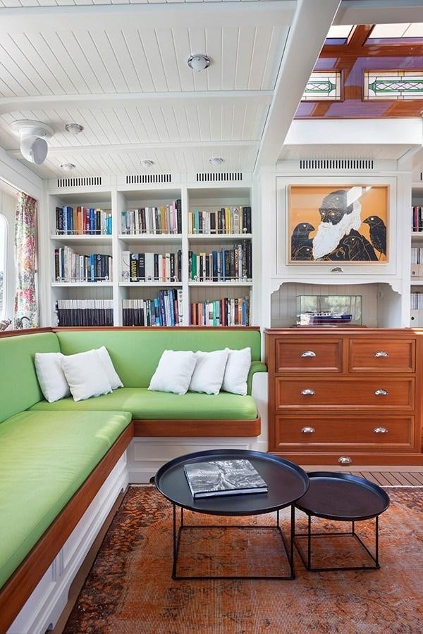 a living room with a green couch and a coffee table aboard DARWIN Yacht for Sale