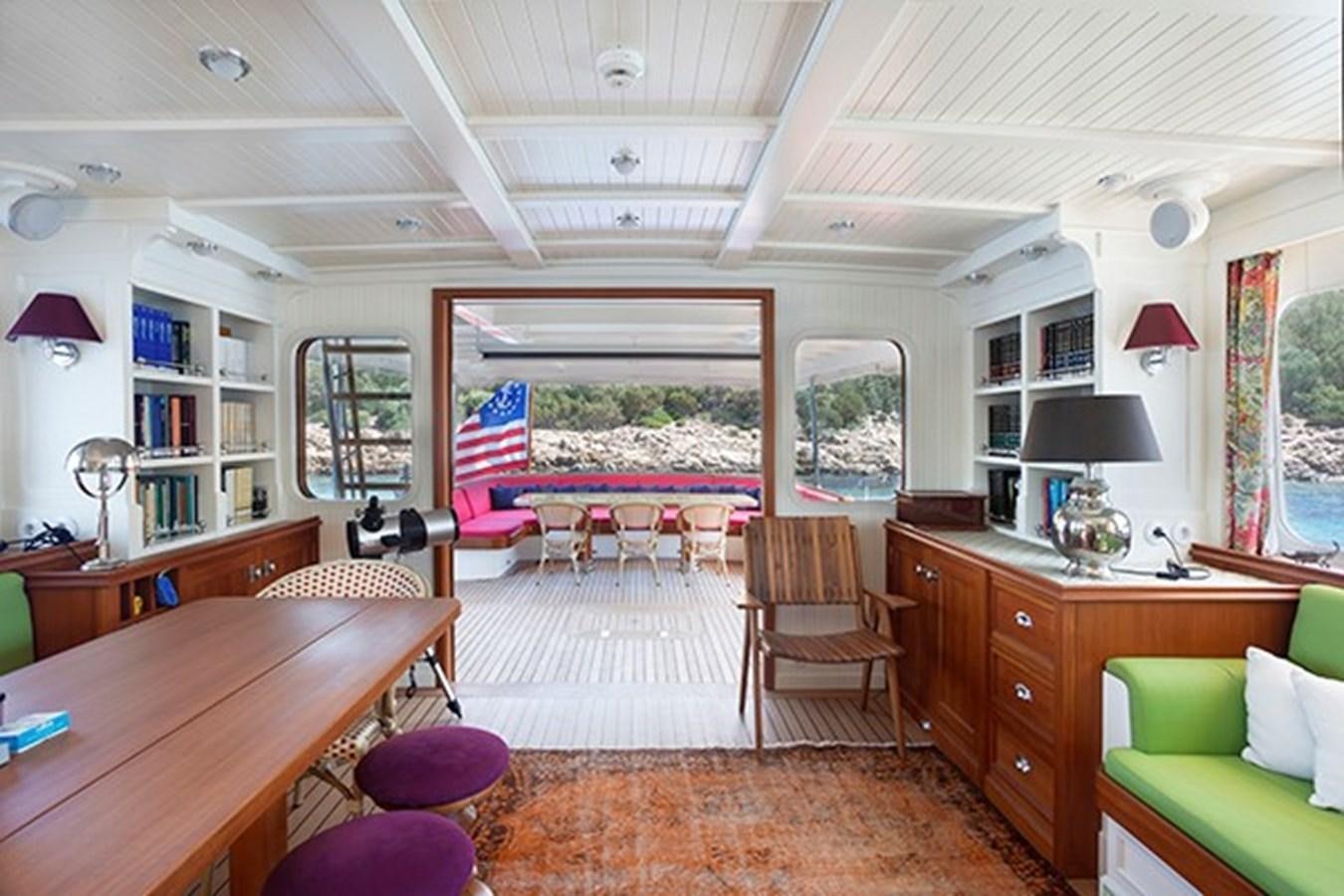 a room with a table chairs and a window aboard DARWIN Yacht for Sale