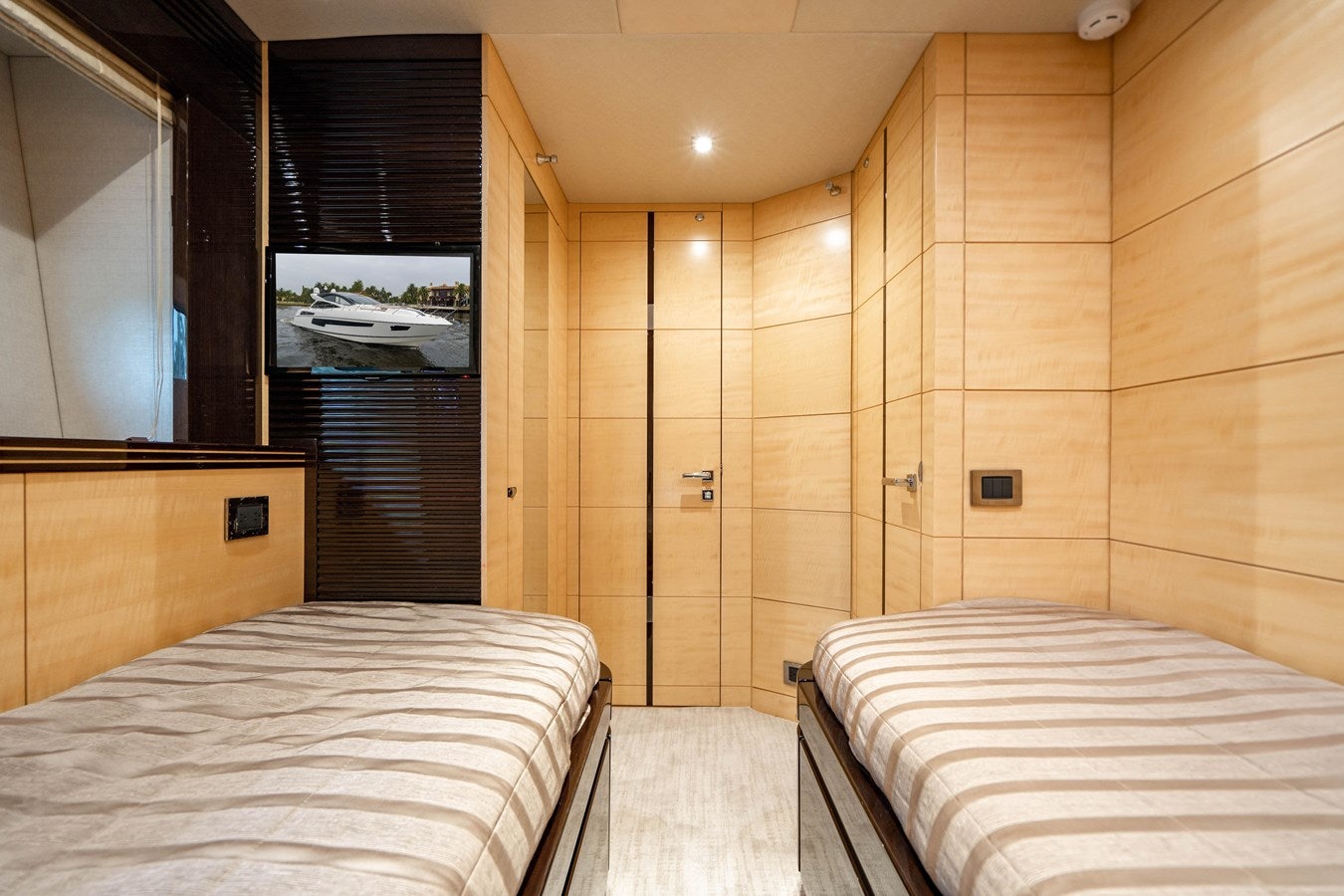 a room with a bed and a television aboard YOLO Yacht for Sale