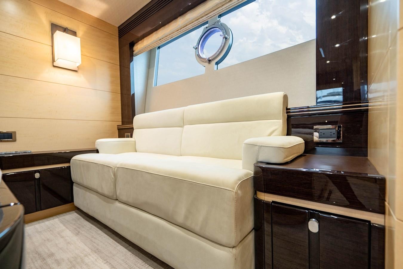 a living room with a couch and a tv aboard YOLO Yacht for Sale