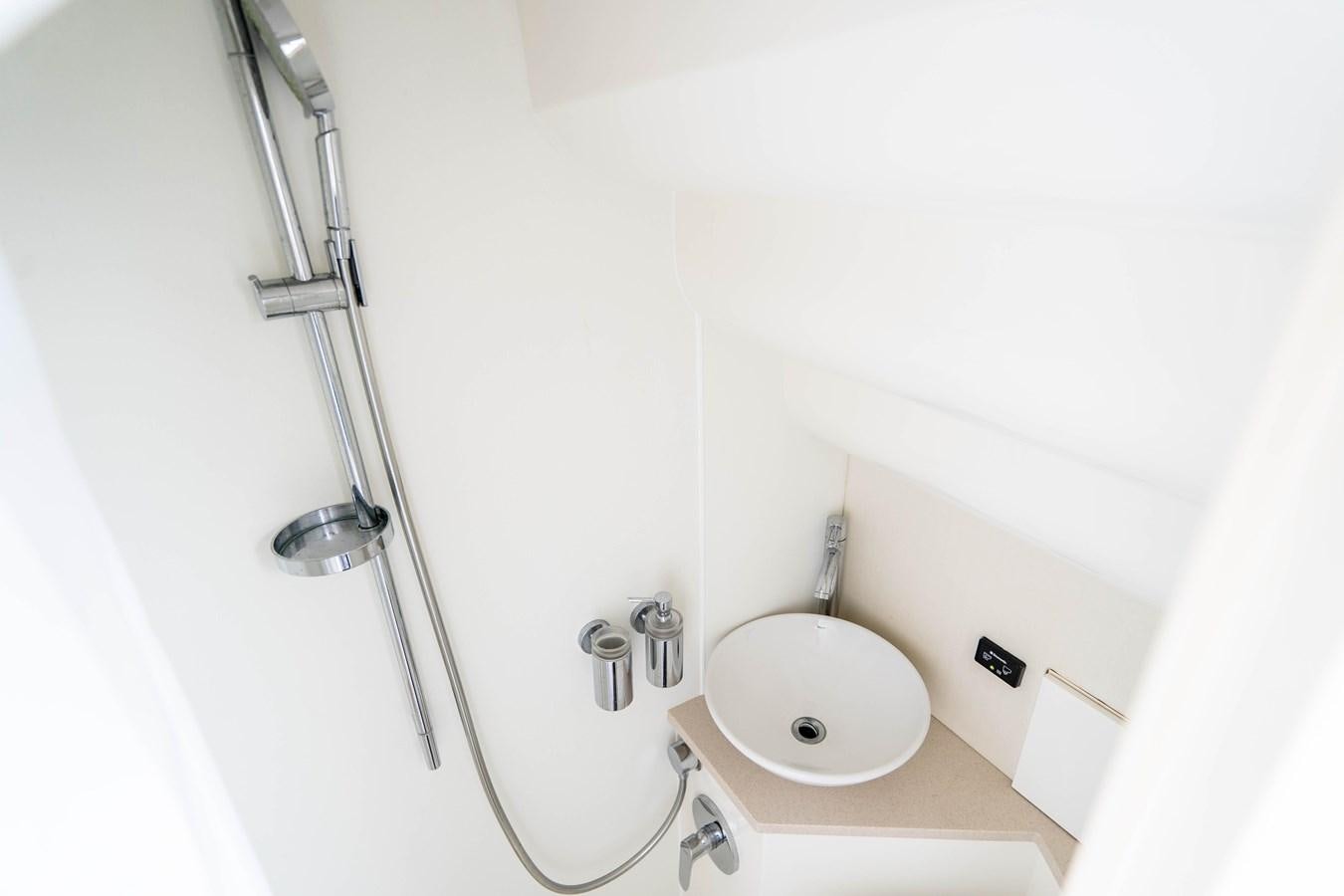 a shower with a sink and a toilet aboard YOLO Yacht for Sale