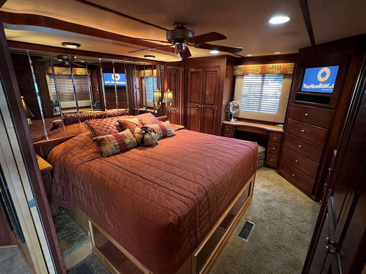 a bedroom with a bed and a tv on the wall aboard 2007 STARDUST 19 X 86WB NLCG Yacht for Sale
