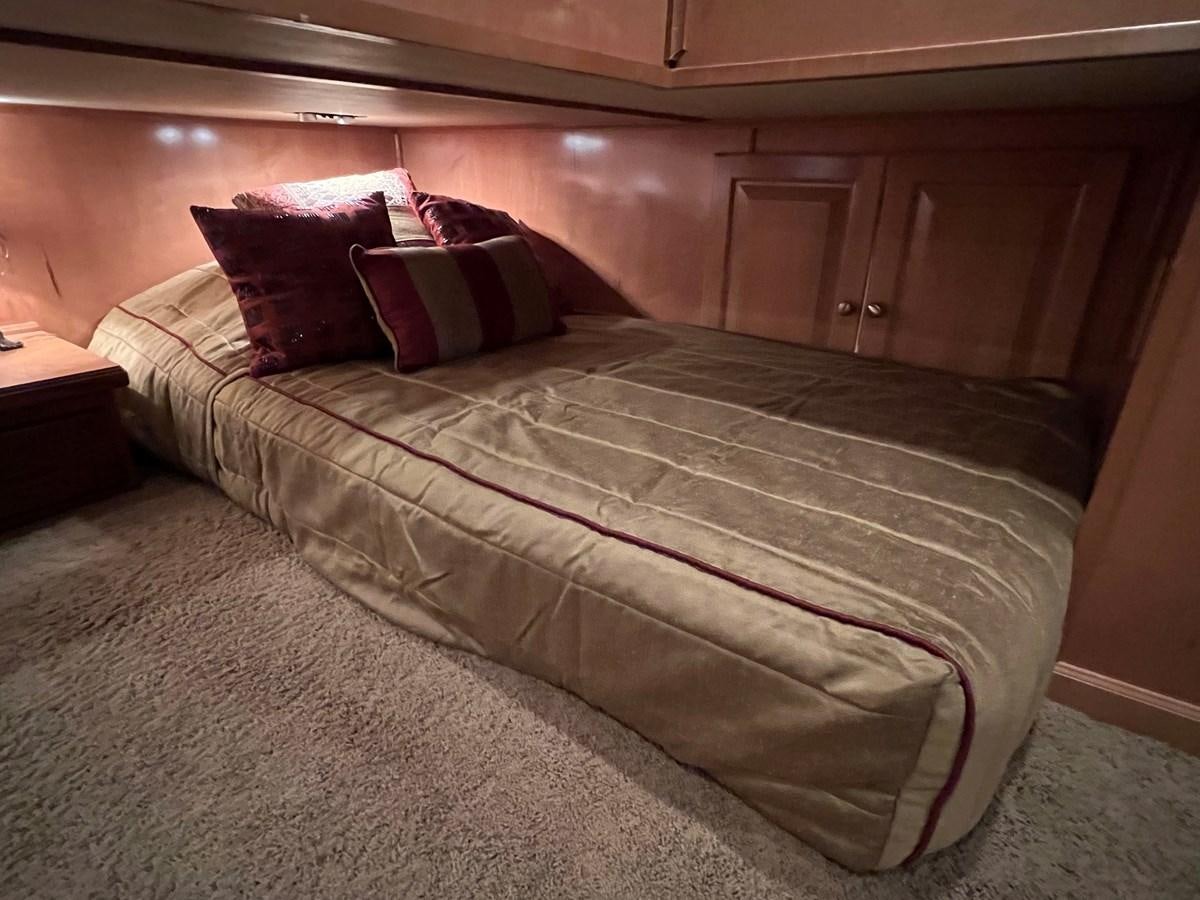 a bed with a red and white comforter aboard 2007 STARDUST 19 X 86WB NLCG Yacht for Sale