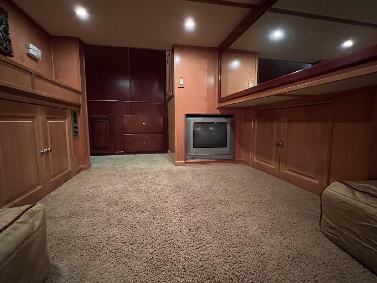 a living room with a tv and wood cabinets aboard 2007 STARDUST 19 X 86WB NLCG Yacht for Sale