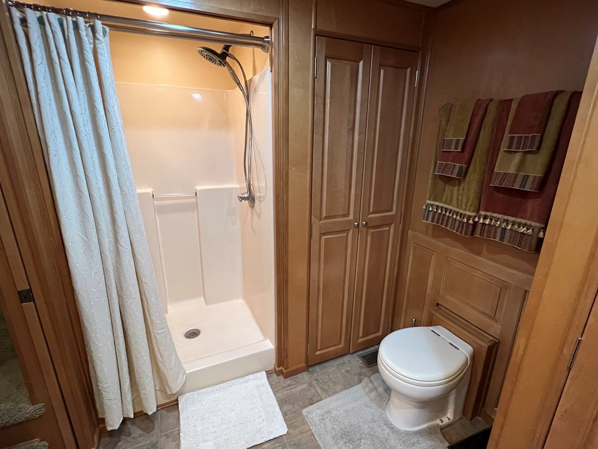 a bathroom with a toilet and a shower aboard 2007 STARDUST 19 X 86WB NLCG Yacht for Sale