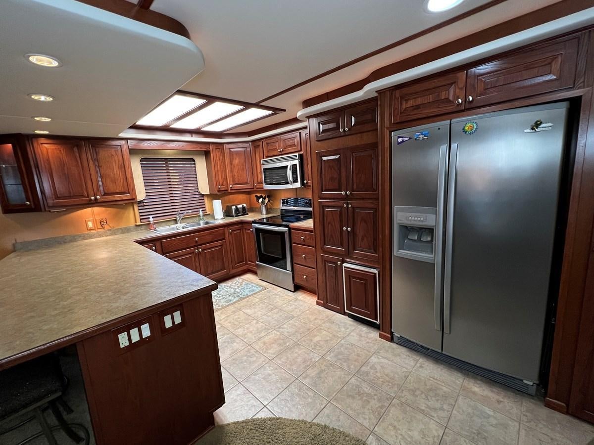 a kitchen with wooden cabinets aboard 2007 STARDUST 19 X 86WB NLCG Yacht for Sale