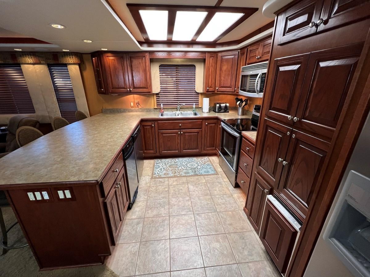 a kitchen with wooden cabinets aboard 2007 STARDUST 19 X 86WB NLCG Yacht for Sale