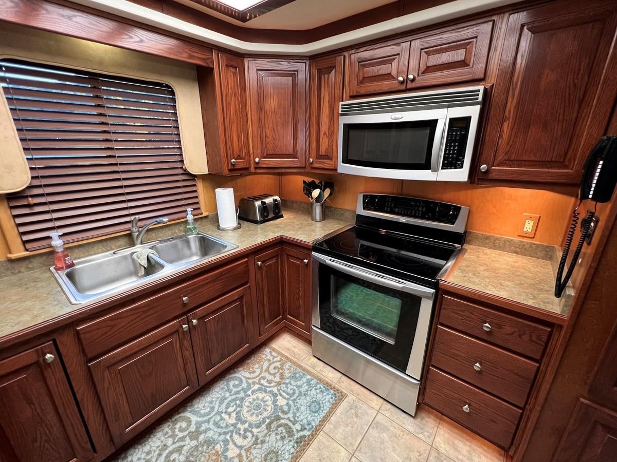 a kitchen with wooden cabinets aboard 2007 STARDUST 19 X 86WB NLCG Yacht for Sale