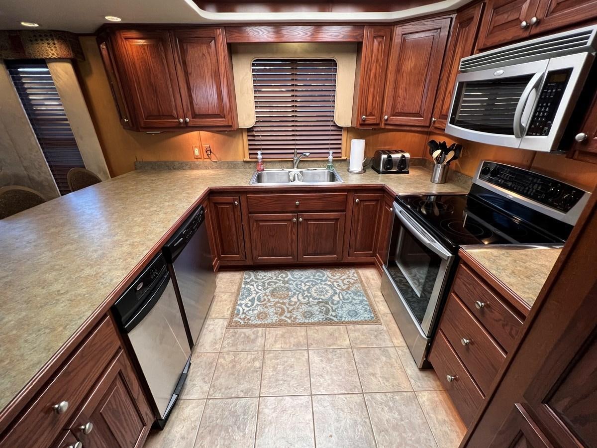 a kitchen with wooden cabinets aboard 2007 STARDUST 19 X 86WB NLCG Yacht for Sale