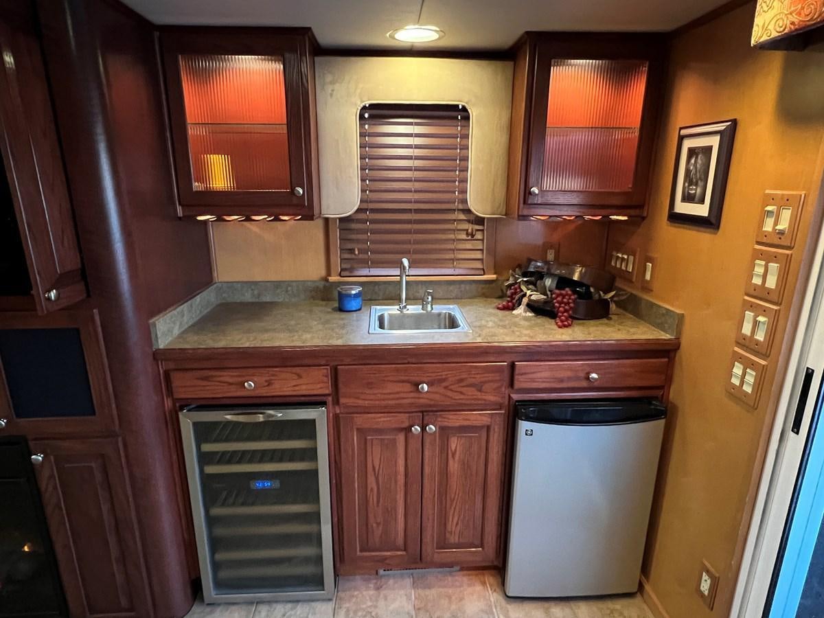 a kitchen with wooden cabinets aboard 2007 STARDUST 19 X 86WB NLCG Yacht for Sale