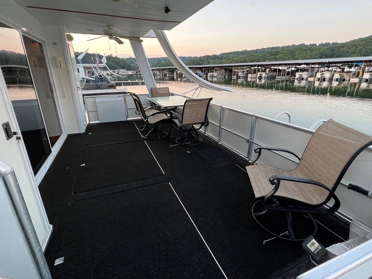 a deck with chairs and tables on it aboard 2007 STARDUST 19 X 86WB NLCG Yacht for Sale