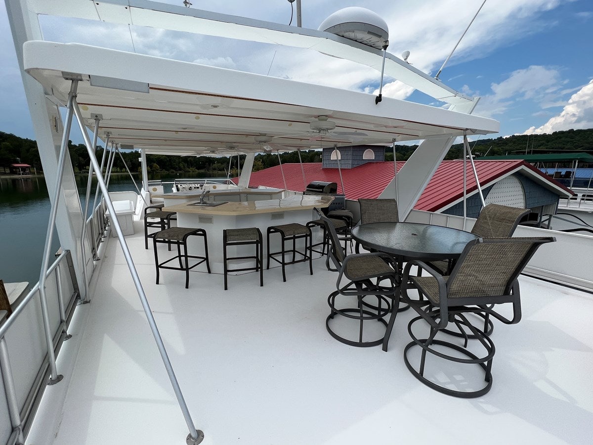 a deck with chairs and tables on it aboard 2007 STARDUST 19 X 86WB NLCG Yacht for Sale