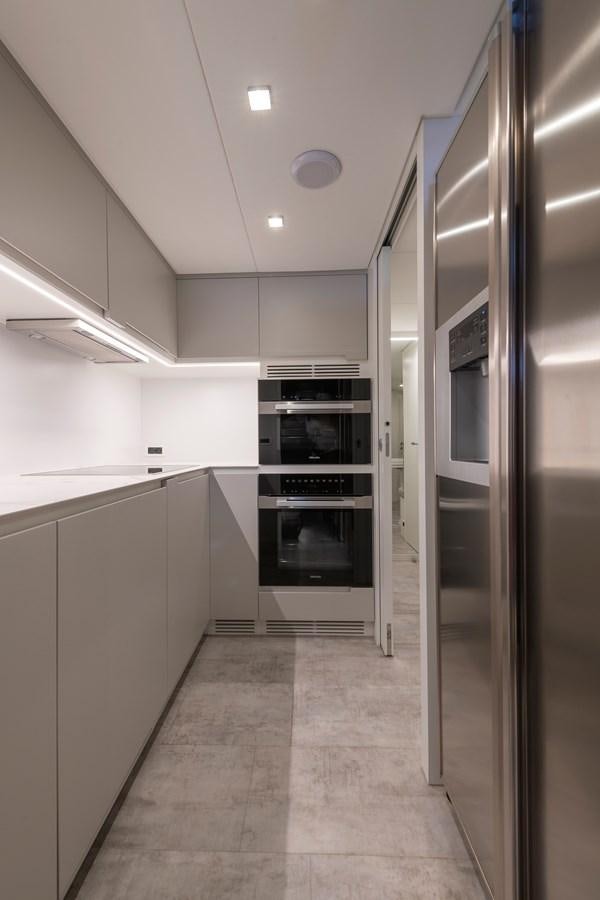 a kitchen with white cabinets aboard CUCU Yacht for Sale