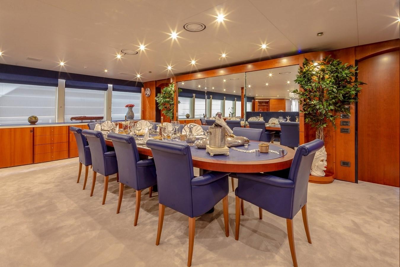 a large dining room with blue chairs aboard LUCY III Yacht for Sale