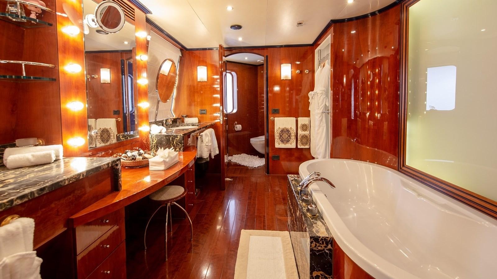 a bathroom with a bathtub and sinks aboard LUCY III Yacht for Sale
