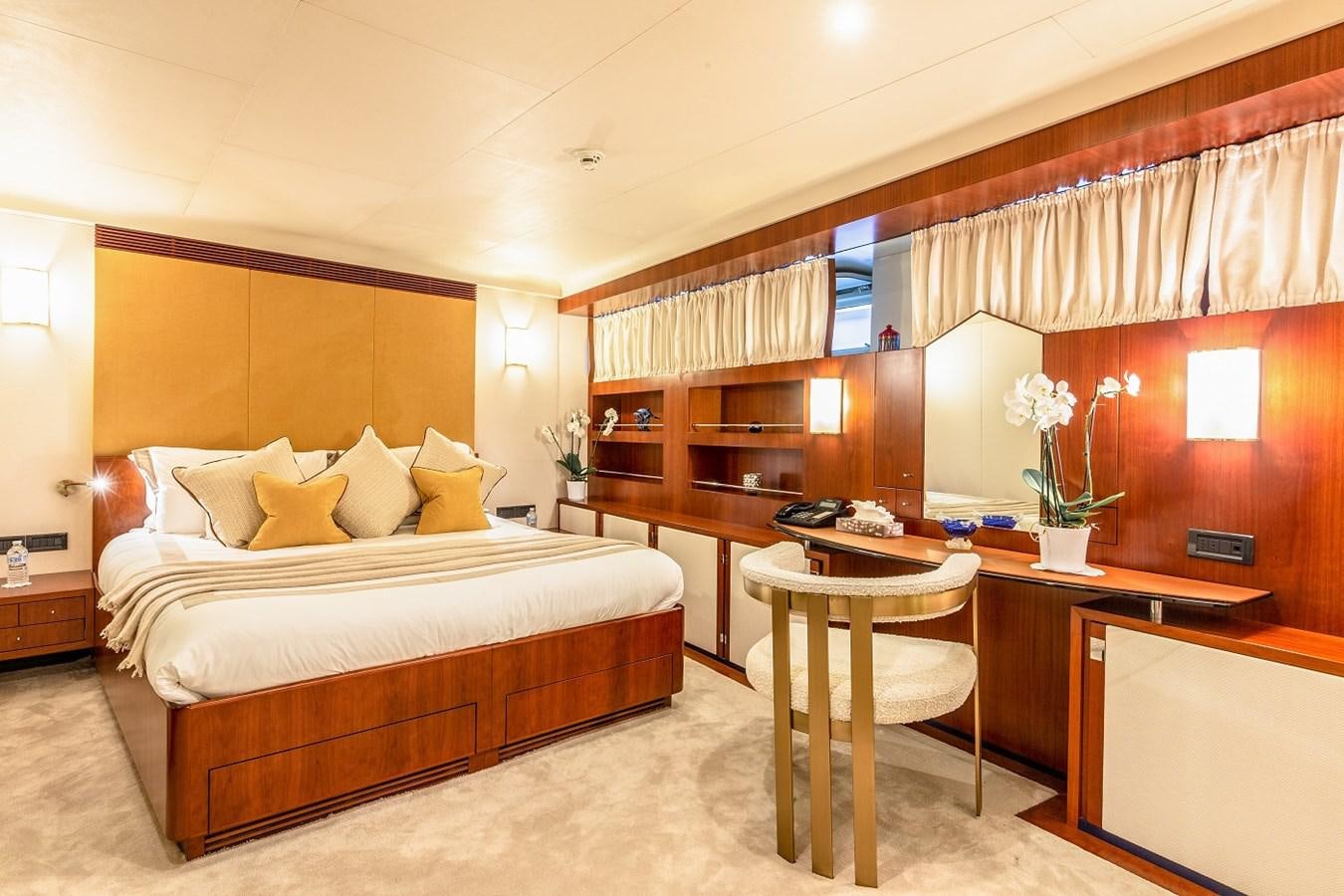 a bedroom with a bed and desk aboard LUCY III Yacht for Sale