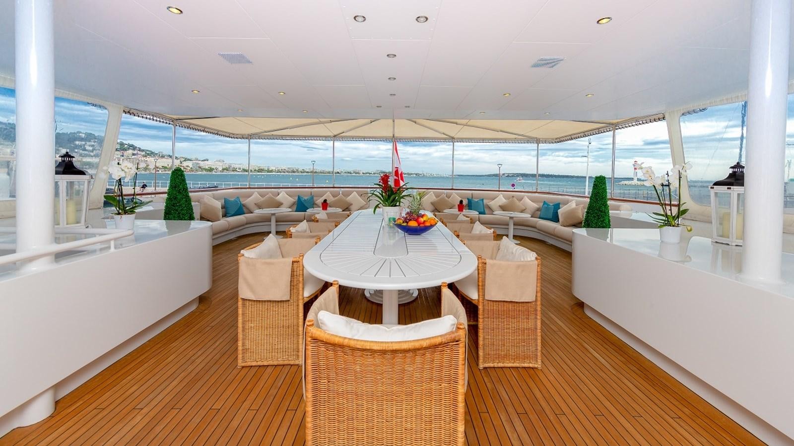 a room with a table chairs and plants aboard LUCY III Yacht for Sale