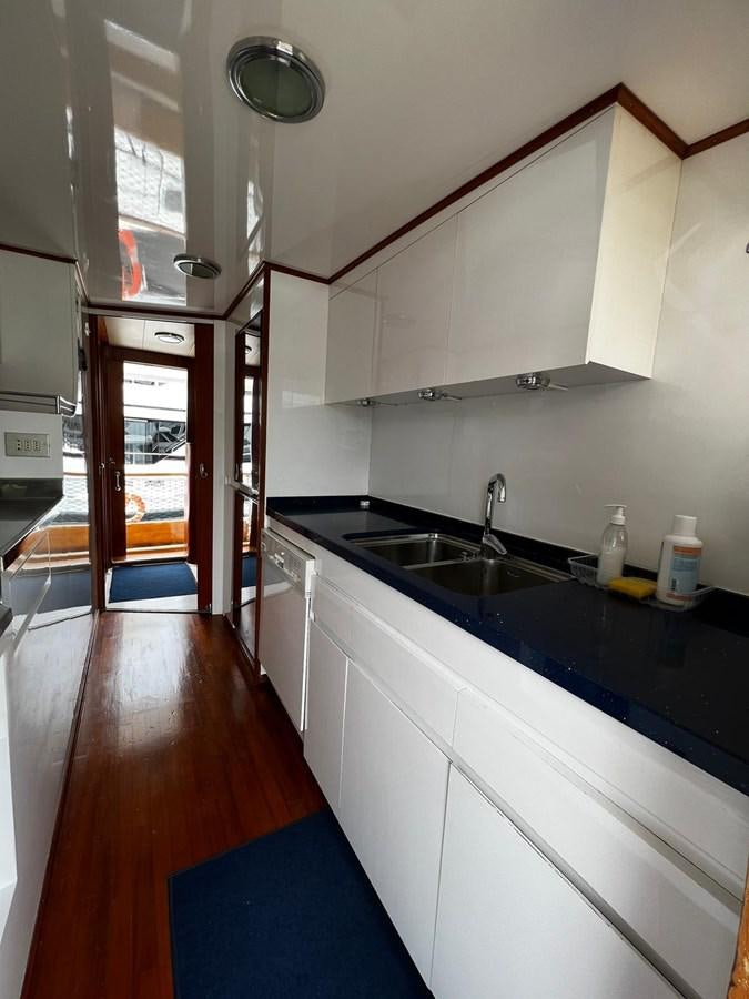 a kitchen with a wood floor aboard QUADRIFOGLIO Yacht for Sale