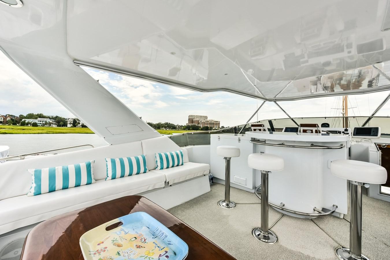 a room with a table and stools and a large window aboard BOOGIE BABE III Yacht for Sale