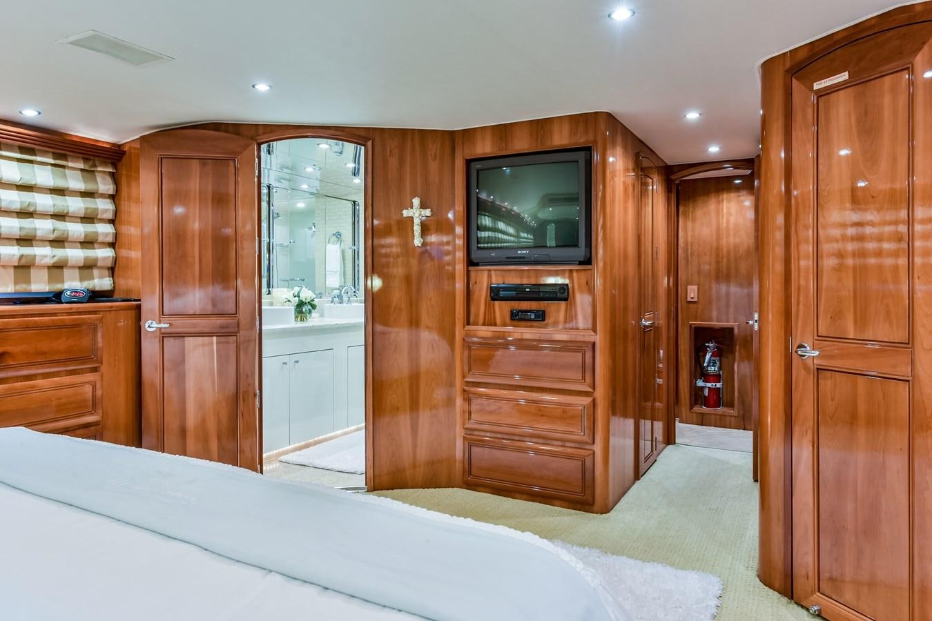 a bedroom with a bed and a television aboard BOOGIE BABE III Yacht for Sale