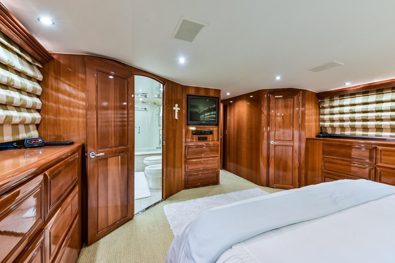 a bedroom with a bed and a television aboard BOOGIE BABE III Yacht for Sale