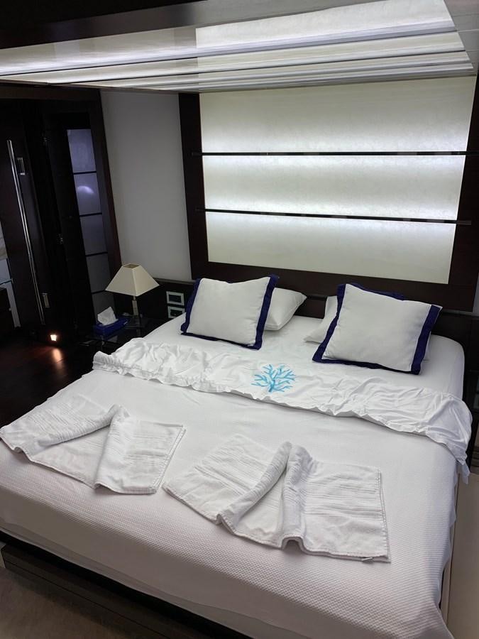 a bed with white sheets aboard SURVIVOR Yacht for Sale