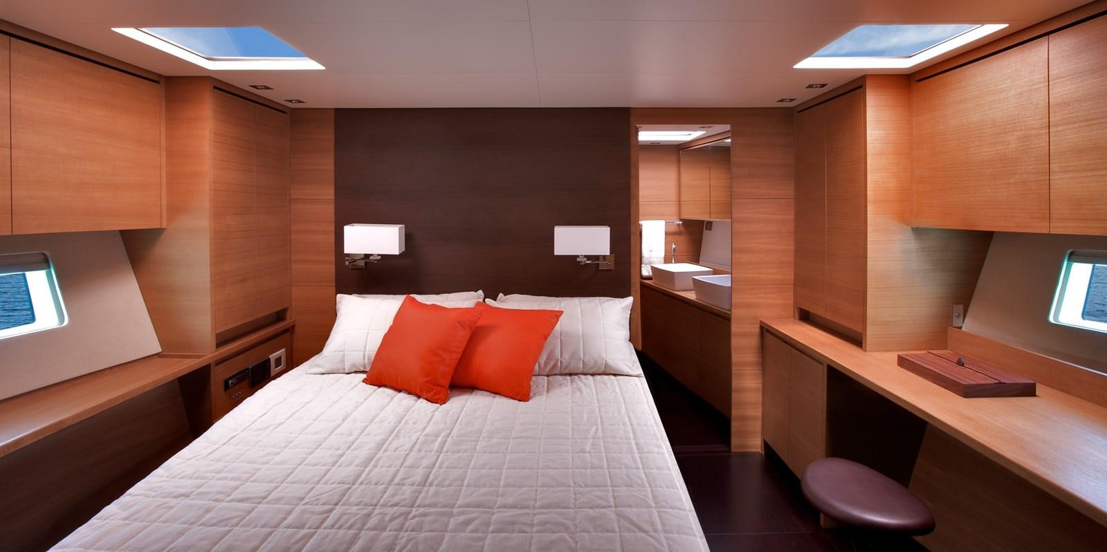 a room with a bed and desk aboard INDIO Yacht for Sale