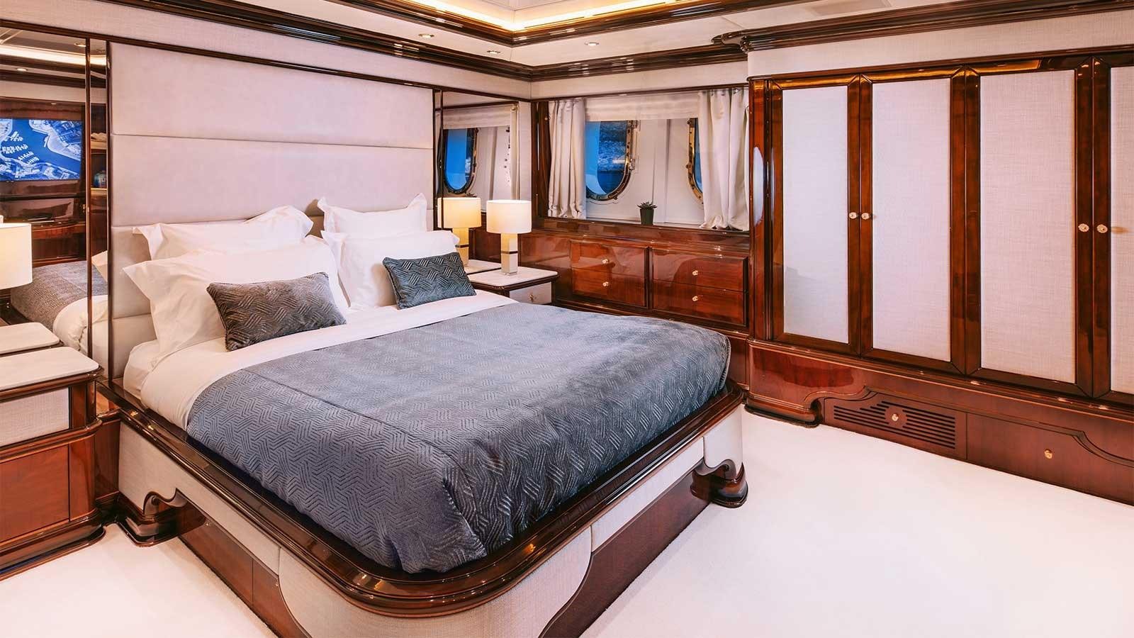 a bed with a blue sheet aboard IDYLLIC Yacht for Charter