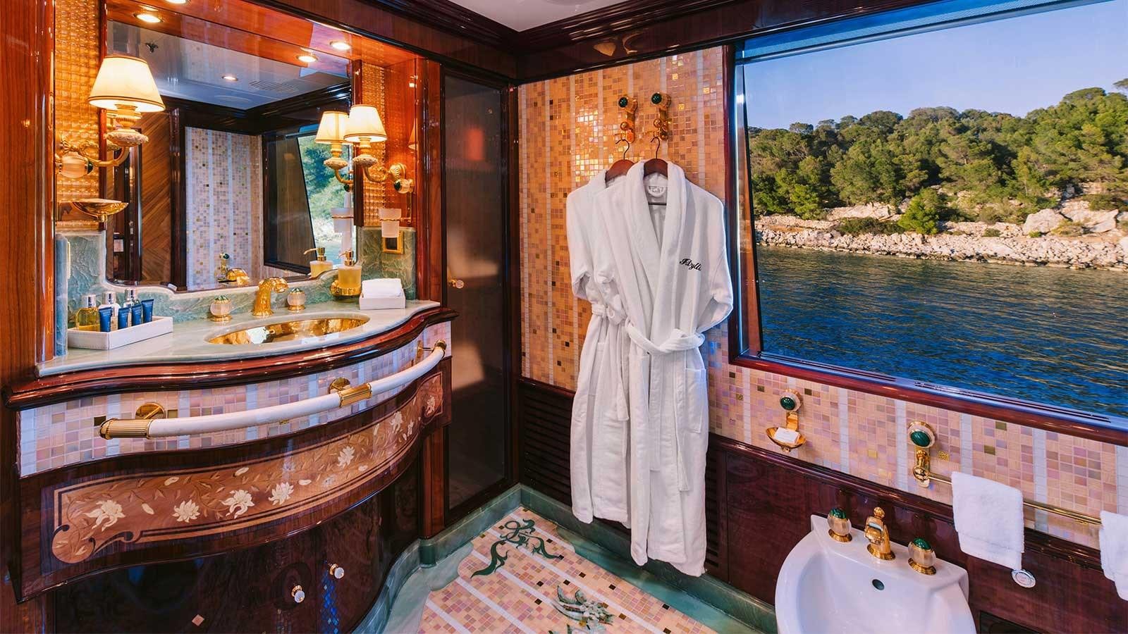 a bathroom with a robe on the wall aboard IDYLLIC Yacht for Charter